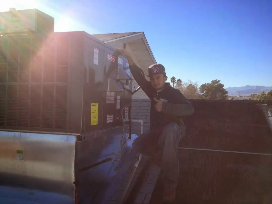 HVAC technician performing AC Tune-Up on a rooftop unit in Woodland Park